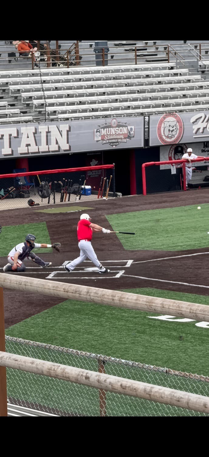 Coach Zack at the plate mid-swing during a game at Munson Stadium
